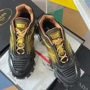 PRADA 26S CLOUDBUST THUNDER SNEAKERS 60MM IN BLACK AND GOLD MESH FABRIC AND TPU