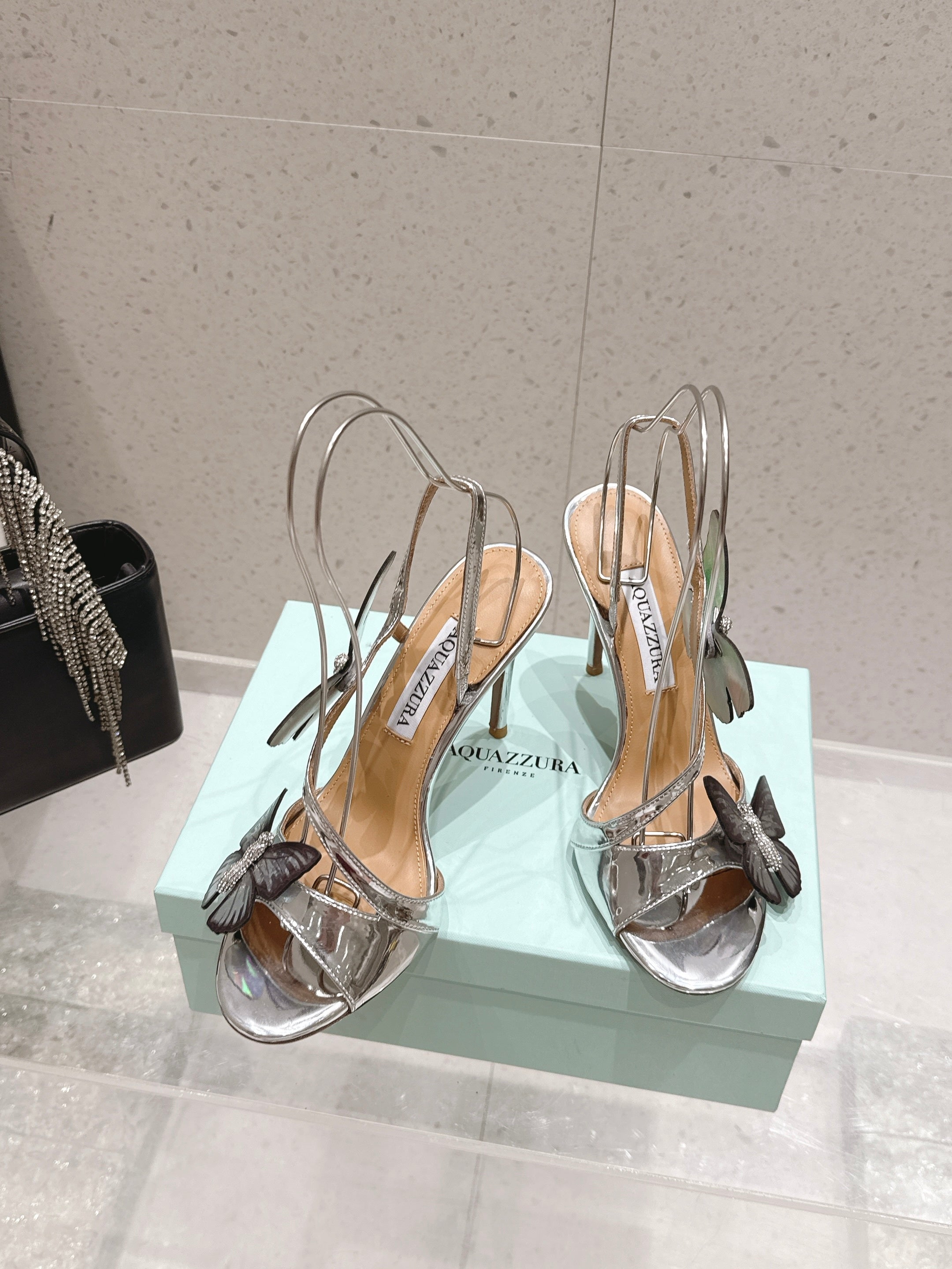 AQUAZZURA 26S BUTTERFLY HEEL SANDALS 100 MM IN SILVER CALFSKIN