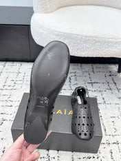 ALAIA 26S FLAT SLIP-ONS IN BLACK CALFSKIN WITH OPENWORK PATTERN