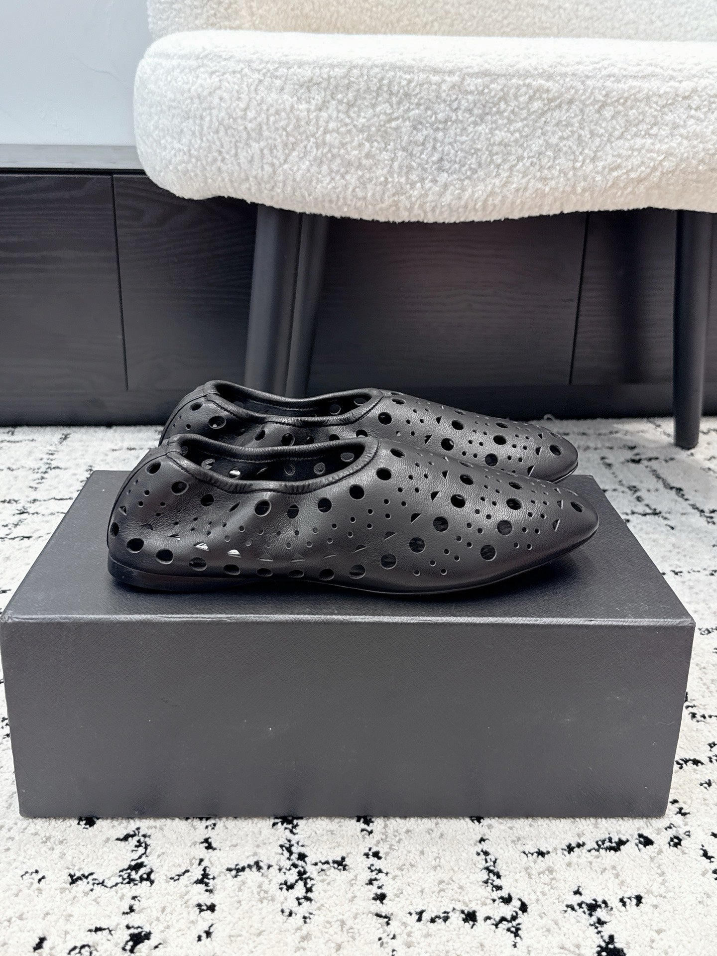 ALAIA 26S FLAT SLIP-ONS IN BLACK CALFSKIN WITH OPENWORK PATTERN
