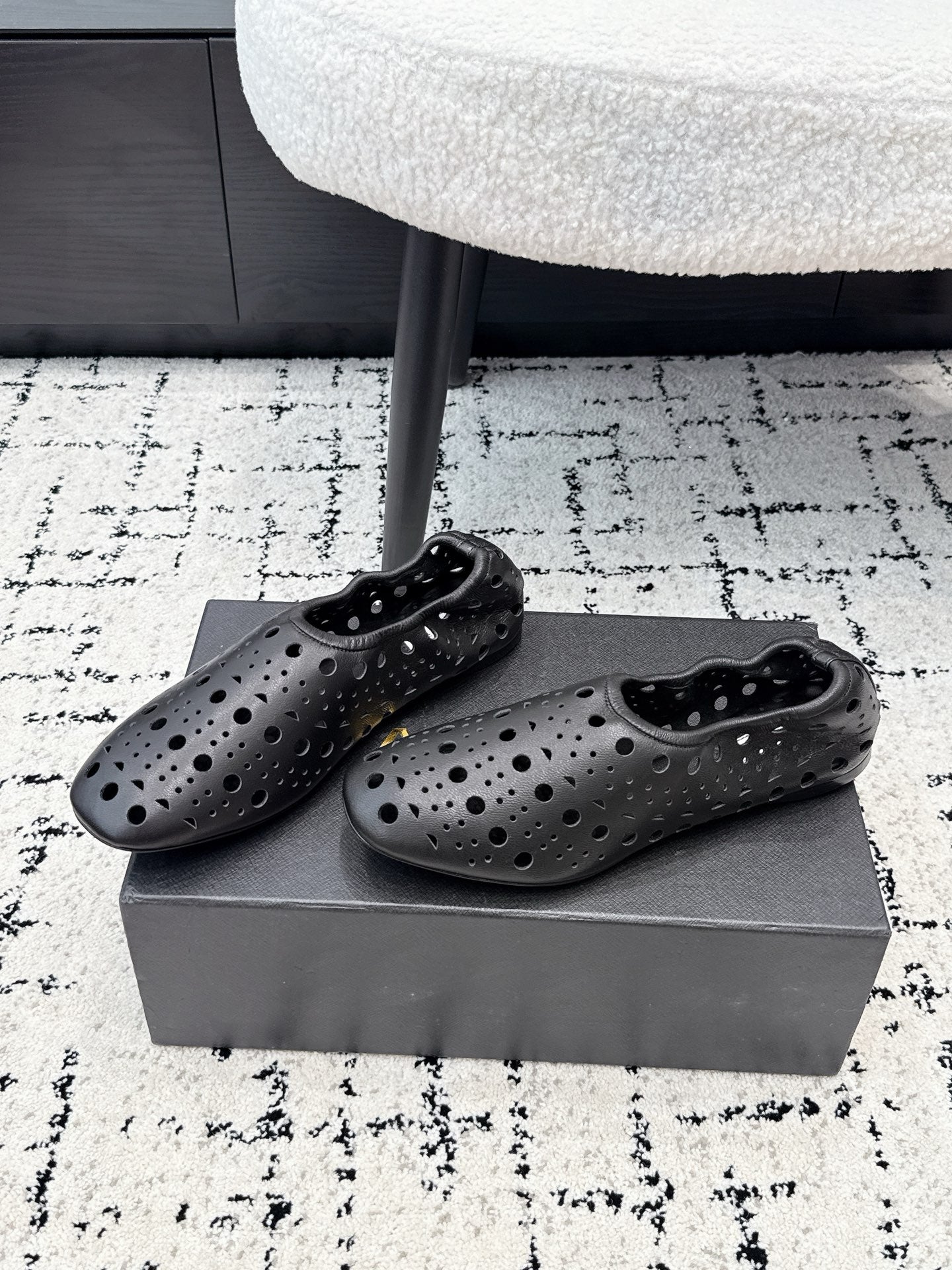 ALAIA 26S FLAT SLIP-ONS IN BLACK CALFSKIN WITH OPENWORK PATTERN