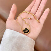 MIUMIU 26S LOGO ROUND BRACELET IN BLACK ENAMEL AND GOLD TONE METAL 631809