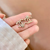 CHANEL 26S DOUBLE C LOGO PEARL STUD EARRINGS WITH FLORAL DETAIL IN GOLD METAL 631917