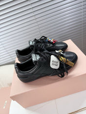 MIUMIU 26S GYMNASIUM SNEAKER IN BLACK CALFSKIN WITH GOLD BUCKLED STRAP
