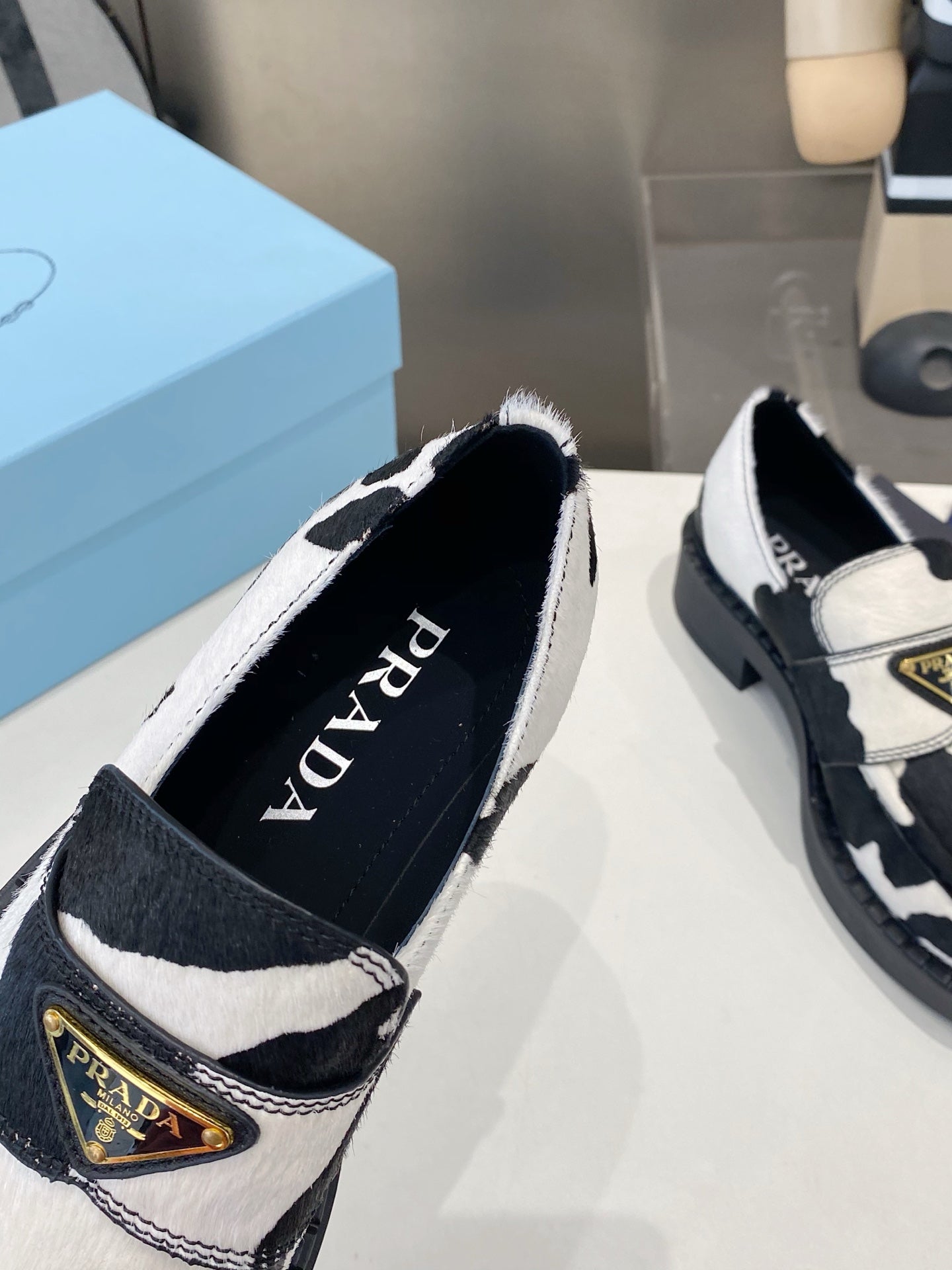 PRADA 26S LOAFERS IN WHITE AND BLACK COW PRINT PONY HAIR