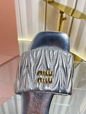 MIUMIU 26S MATELASSE SLIDES IN SILVER CALFSKIN GOLD HARDWARE